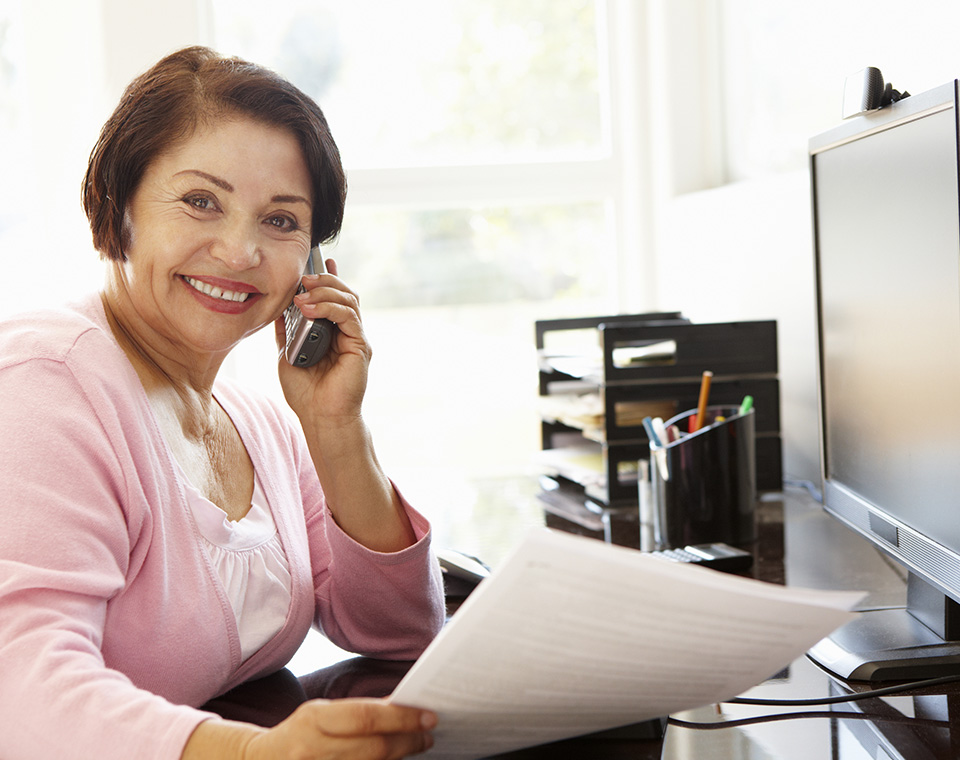 Smiling mature teacher giving class through telephone - Online teaching jobs
